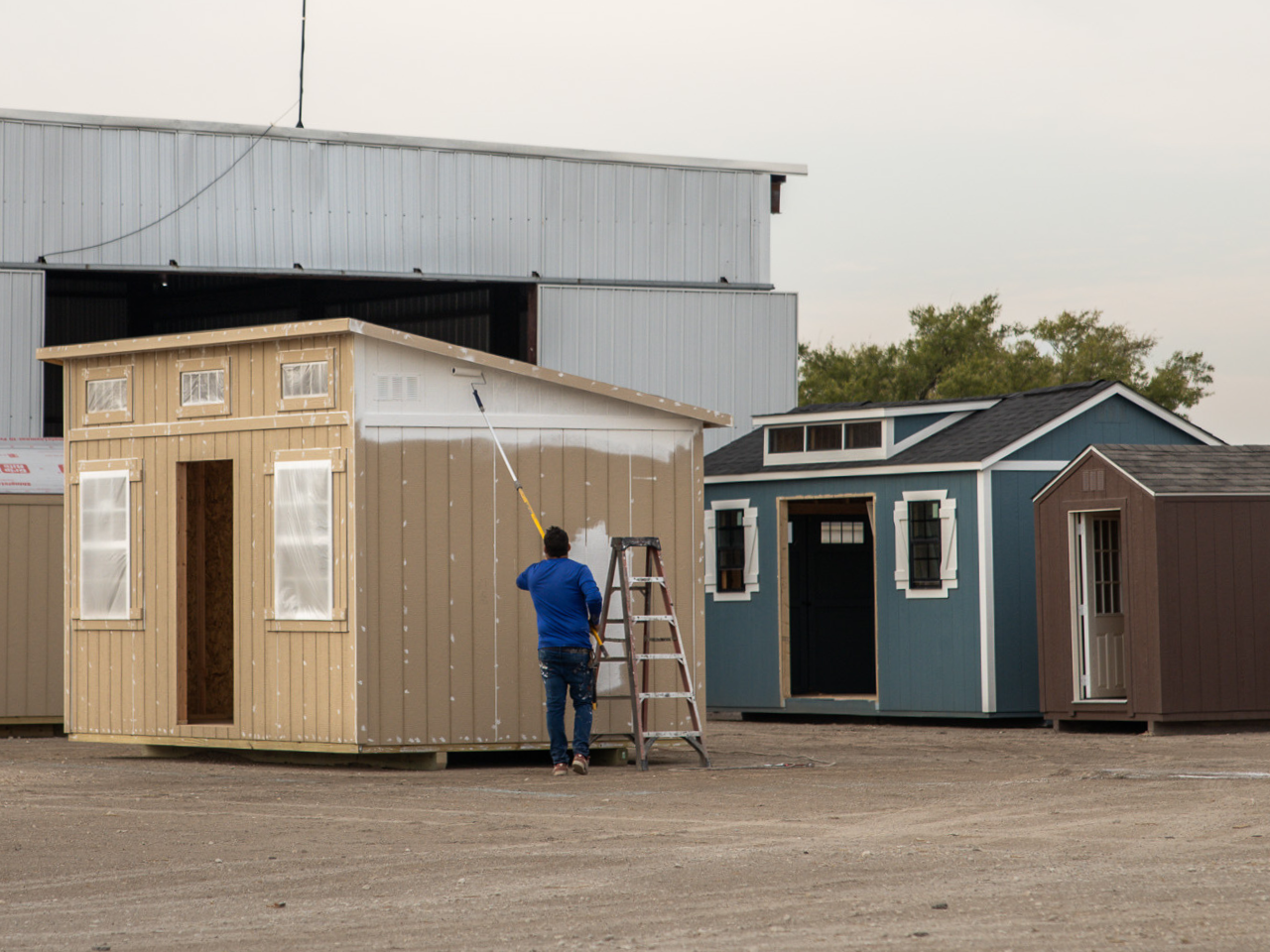 a person painting a portable shed